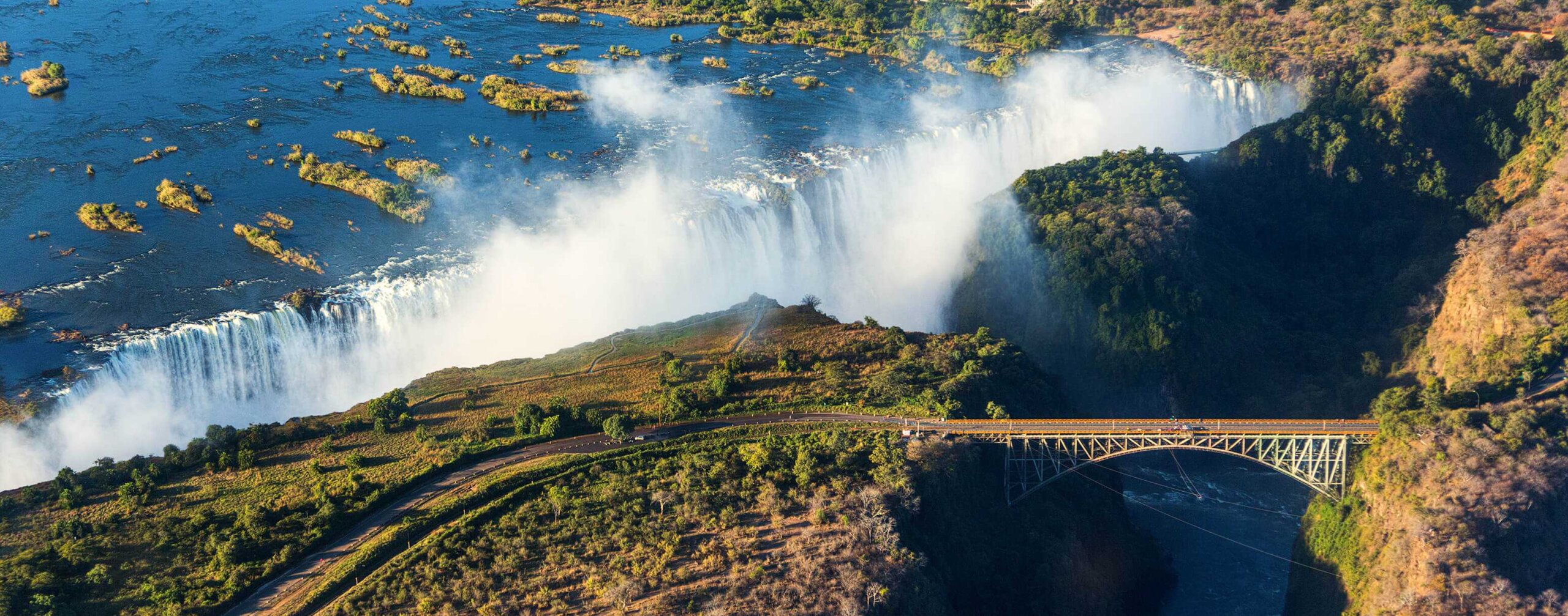 Victoria Falls with microlight and rainbow